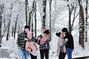 family laughing and playing in the snow