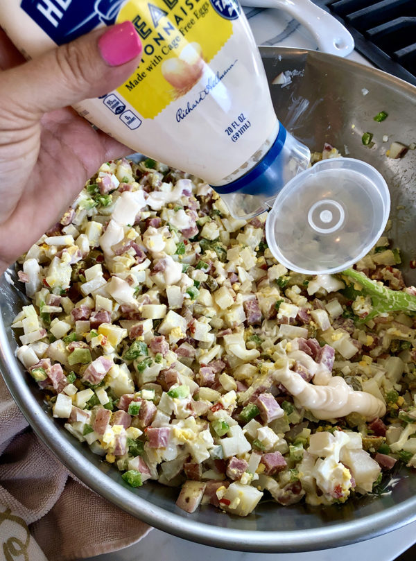 squeezing mayonnaise into bowl of mixed ingredients