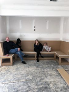 family seated at banquette table during construction process
