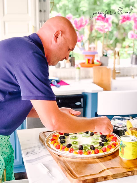 Placing fruit on pizza